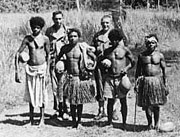 Back row. ASTC staff Mayo Stuntz (L) and Homer Williams (R) with natives near Kalo, Kalo, Fergusson Island, New Guinea.